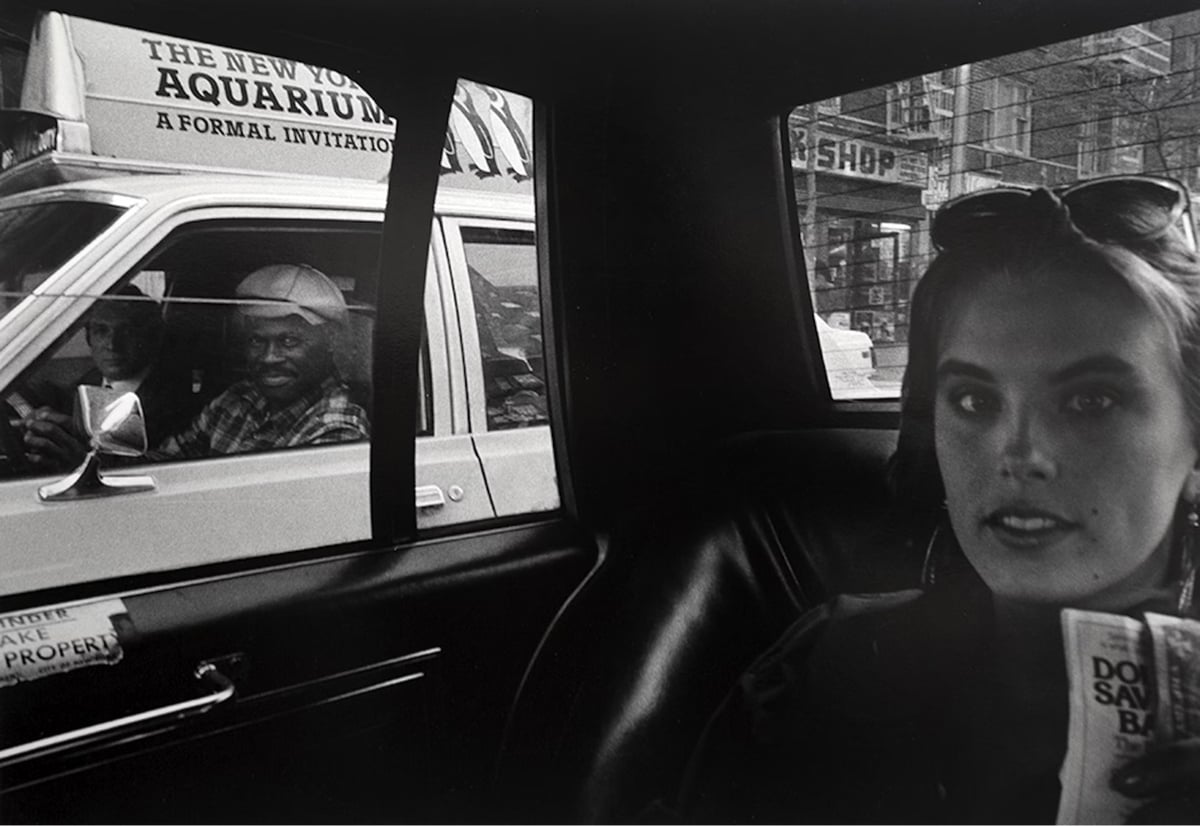 a woman sitting in the back of a cab