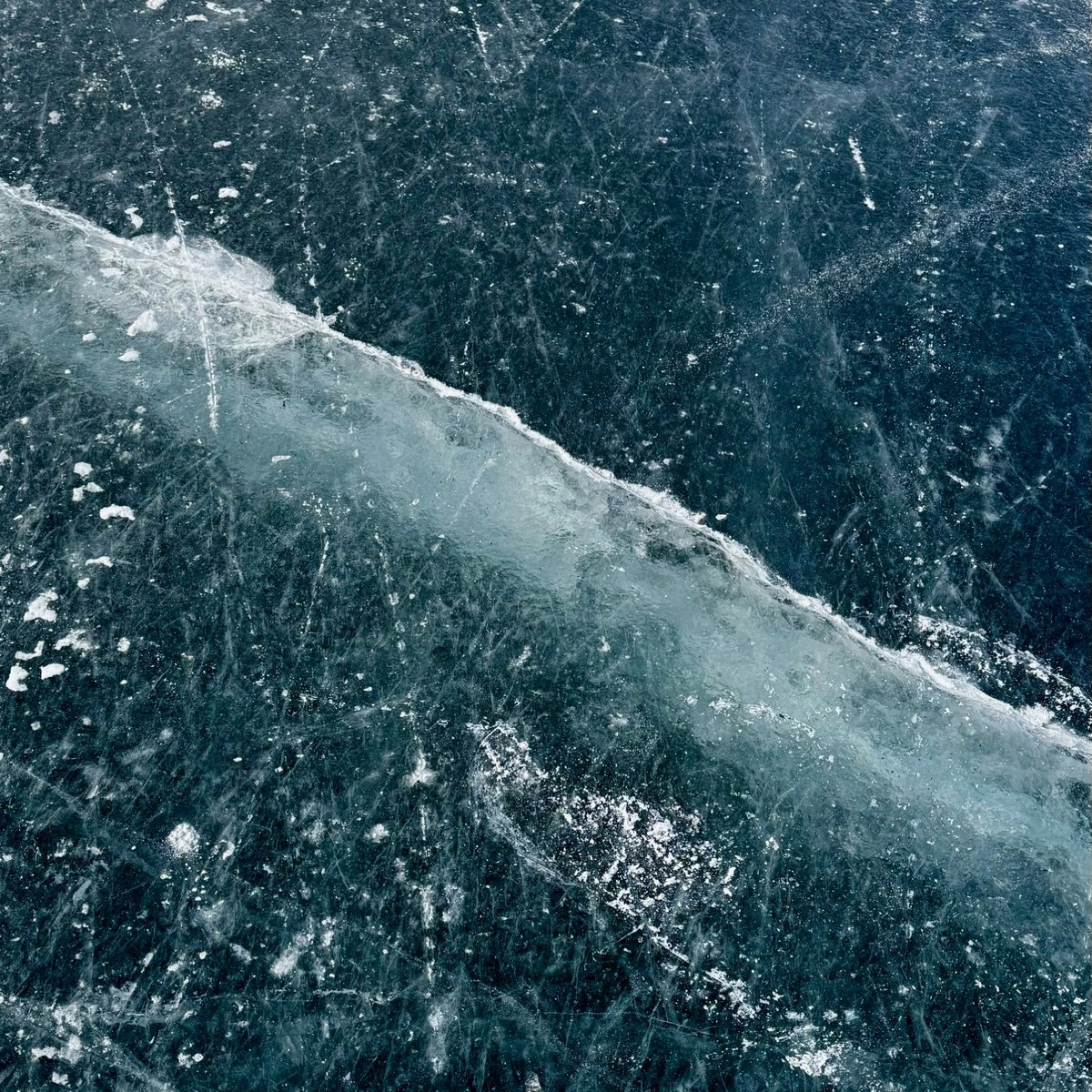 lake ice with cracks and marks from ice skates