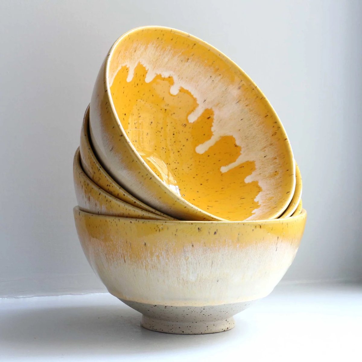 a stack of three yellow and white bowls