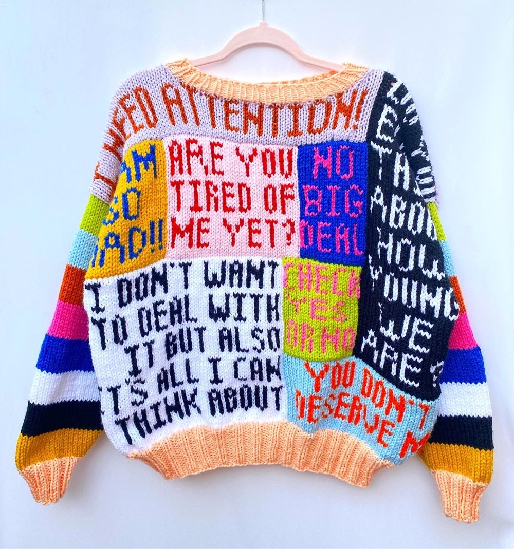 a sweater with several brightly colored patches with knitted words
