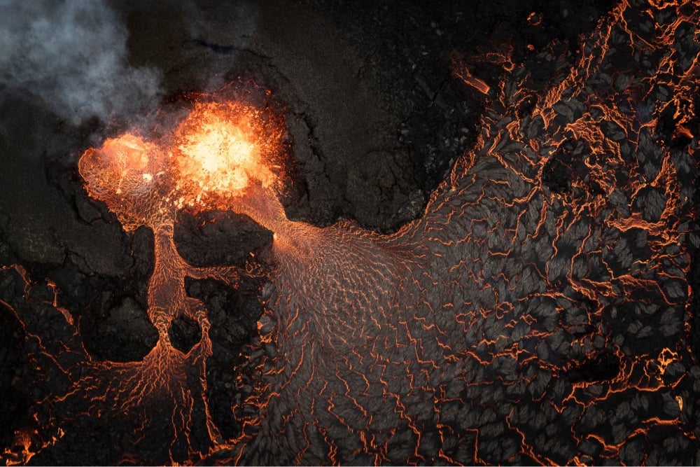 overhead view of a volcanic eruption with lava pouring out