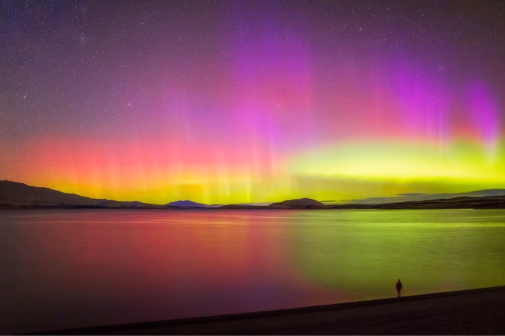 intense pink and yellow aurora in the night sky