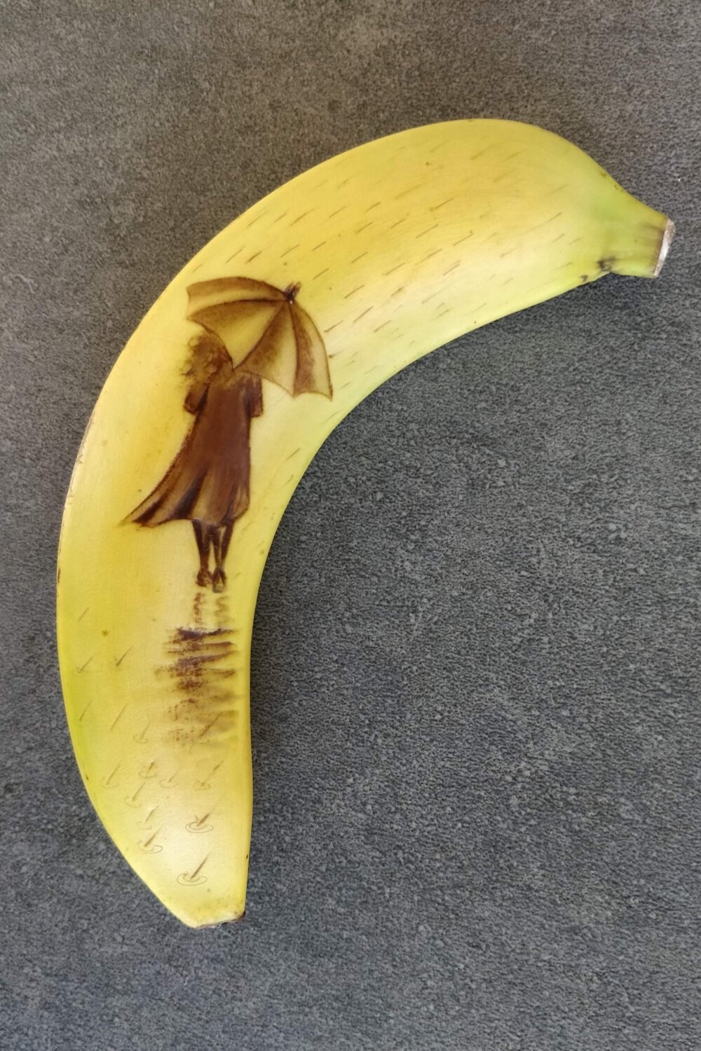 art of a girl with an umbrella in the rain imprinted on a banana