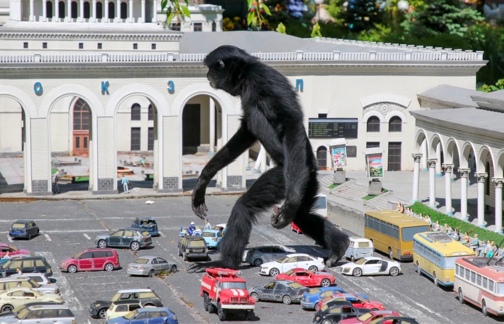 a monkey walks though a scale model of a city