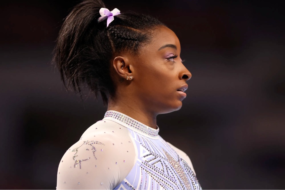 Simone Biles wearing a leotard with a picture of a goat sown into it